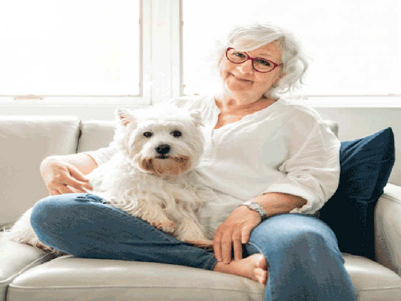 Elderly woman in senior in home care with a dog