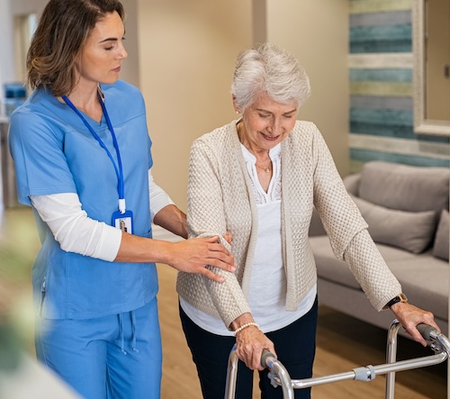 Senior woman being helped by a nurse on her walker to prevent a fall