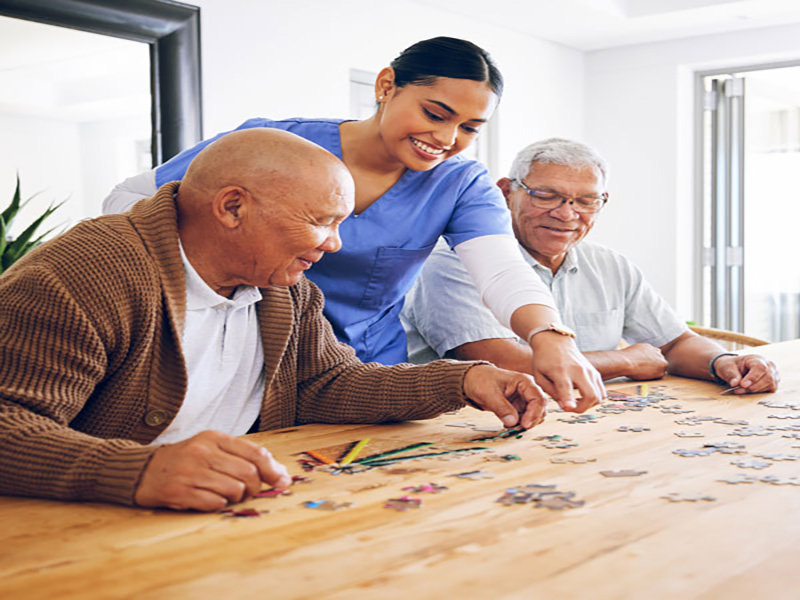 2 seniors in an assisted living facility building a puzzle