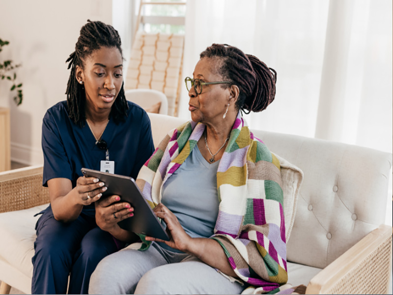 senior and caregiver on a couch
