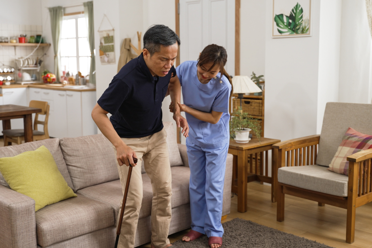 an elderly male getting assistance from a senior caregiver