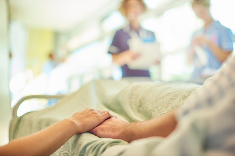 an elderly patient in a hospital bed with a family visitor and medical care team